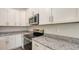 Close up of modern kitchen featuring granite counters, stainless appliances, and white cabinets at 2926 River Run Way, Bradenton, FL 34208