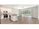 Open-concept kitchen with white cabinets, granite countertops, and stainless steel appliances at 2926 River Run Way, Bradenton, FL 34208