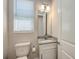 Elegant powder room featuring a granite countertop and a modern mirror at 2926 River Run Way, Bradenton, FL 34208
