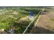 Aerial view highlighting a home with an outbuilding along a straight dirt road, pinpointed with a location marker at 29527 Maris Dr, Punta Gorda, FL 33982