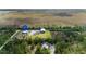 Aerial view of a property including home, large outbuilding, pond, and surroundings marked with a location pin at 29527 Maris Dr, Punta Gorda, FL 33982
