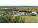 Expansive property featuring a single-story home, large parking area, outbuilding, and surrounding wooded areas and flatlands at 29527 Maris Dr, Punta Gorda, FL 33982