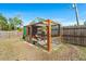 Enclosed chicken coop featuring wire mesh walls, a hanging plant, and a gated entrance at 29527 Maris Dr, Punta Gorda, FL 33982