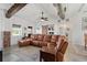 Spacious living room with a comfortable leather sectional, exposed ductwork, neutral rug, and access to other living spaces at 29527 Maris Dr, Punta Gorda, FL 33982