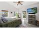 Bright main bedroom featuring a platform bed, concrete floors, flatscreen TV, and three windows for natural light at 29527 Maris Dr, Punta Gorda, FL 33982