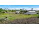 Wide shot of property featuring large open field, long driveway and metal outbuilding at 29527 Maris Dr, Punta Gorda, FL 33982