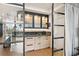 Stylish bar area featuring sleek cabinets, a marble countertop, and glass shelving at 3030 Grand Bay Blvd # 324, Longboat Key, FL 34228