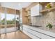 Modern kitchen featuring white cabinets, quartz countertops, and balcony access at 3030 Grand Bay Blvd # 324, Longboat Key, FL 34228