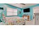 Well-lit bedroom featuring a beach themed comforter, and a modern TV on the wall at 3112 Cambridge Ave # 6, Bradenton, FL 34207