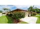 Exterior of the home featuring a terracotta roof, lush landscaping, and well-manicured lawn at 3112 Cambridge Ave # 6, Bradenton, FL 34207