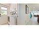Well-lit laundry room with modern appliances, built-in storage, and a view to a hallway of the home at 3112 Cambridge Ave # 6, Bradenton, FL 34207