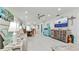 Open-concept living room with white walls and flooring, a large TV, and coastal-themed decor at 3112 Cambridge Ave # 6, Bradenton, FL 34207