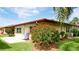 Back exterior of home with well-manicured lawn, terracotta roof, and flowering landscaping at 3112 Cambridge Ave # 6, Bradenton, FL 34207