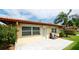 Back exterior of home featuring a terracotta roof, well-manicured lawn, and small patio area at 3112 Cambridge Ave # 6, Bradenton, FL 34207