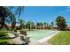 View of community shuffleboard courts surrounded by landscaping and several benches for players at 3112 Cambridge Ave # 6, Bradenton, FL 34207
