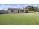 Single-story home with a lush green lawn, stone accents, and a red front door at 3123 40Th W Ave, Bradenton, FL 34205