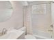 Well-lit bathroom featuring modern fixtures, a round mirror, and a shower with a patterned curtain at 322 S Washington Dr, Sarasota, FL 34236