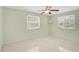 This is a bedroom with neutral paint, two windows, ceiling fan and painted floor at 322 S Washington Dr, Sarasota, FL 34236