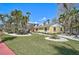 Landscaped yard featuring a yellow single-story home, manicured lawn, white gravel beds and tropical landscaping at 322 S Washington Dr, Sarasota, FL 34236
