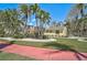 View of a yellow single-story home with a manicured lawn and landscaped yard with multiple palm trees at 322 S Washington Dr, Sarasota, FL 34236
