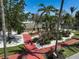 Landscaped yard featuring mature palm trees, vibrant green grass and brick-red driveway at 322 S Washington Dr, Sarasota, FL 34236