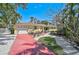 Charming yellow single-story home with a red driveway and beautifully landscaped front yard at 322 S Washington Dr, Sarasota, FL 34236