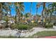 Quaint yellow home with white rock landscaping, mature trees, and green grass at 322 S Washington Dr, Sarasota, FL 34236