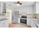 Well-lit kitchen featuring stainless steel appliances, white cabinets, and tile backsplash at 322 S Washington Dr, Sarasota, FL 34236