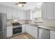 Well-lit kitchen boasts stainless steel appliances, white cabinetry, and modern fixtures at 322 S Washington Dr, Sarasota, FL 34236