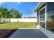 View of spacious backyard featuring manicured lawn, white fence, and screened patio area at 3413 5Th W Dr, Palmetto, FL 34221