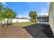 Large backyard with a manicured lawn, mulch beds, and a screened-in lanai at 3413 5Th W Dr, Palmetto, FL 34221