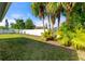 Spacious backyard with lush tropical foliage, grass, and a white privacy fence at 3413 5Th W Dr, Palmetto, FL 34221