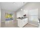 Bright kitchen with white cabinets, island, and access to screened patio at 3413 5Th W Dr, Palmetto, FL 34221