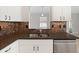The kitchen showcases granite counters, stainless sink, mosaic tile backsplash, and white cabinets at 3413 5Th W Dr, Palmetto, FL 34221