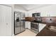 A modern kitchen features stainless steel appliances, white cabinets, granite countertops, and tile floor at 3413 5Th W Dr, Palmetto, FL 34221