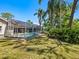 Secluded backyard features a screened-in pool, mature palm trees, and lush landscaping for ultimate relaxation at 3786 Surrey Ln, Sarasota, FL 34235