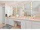 Bathroom with tiled floors, dual sink vanity, and Hollywood style lighting around the mirrors at 3786 Surrey Ln, Sarasota, FL 34235