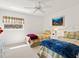 Cozy bedroom featuring twin beds, ceiling fan, and a bright window offering plenty of natural light at 3786 Surrey Ln, Sarasota, FL 34235