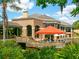 Exterior view of a clubhouse featuring outdoor seating, lush landscaping, and a serene waterfront setting at 3786 Surrey Ln, Sarasota, FL 34235