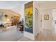 Neutral hallway transitioning into a living room with vaulted ceilings, a vintage organ, and views of the dining room at 3786 Surrey Ln, Sarasota, FL 34235