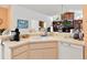Eat-in kitchen with white cabinetry and breakfast bar overlooking living room at 3786 Surrey Ln, Sarasota, FL 34235