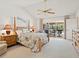 Spacious bedroom with vaulted ceiling, ceiling fan, and sliding glass door to patio at 3786 Surrey Ln, Sarasota, FL 34235