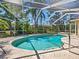 Private screened-in pool offers a refreshing escape with lush landscaping and comfortable lounging area at 3786 Surrey Ln, Sarasota, FL 34235