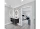 Bathroom leading into the primary bedroom with oval vanity mirrors and a large walk-in shower at 3941 14Th Ne Ln, St Petersburg, FL 33703