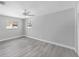 Bright, airy bedroom has neutral walls, ceiling fan, and stylish gray wood-look flooring at 3941 14Th Ne Ln, St Petersburg, FL 33703