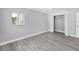 Bedroom with closet, window, neutral walls, ceiling fan, and gray wood-look flooring at 3941 14Th Ne Ln, St Petersburg, FL 33703