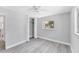 Bedroom with closet, window, ceiling fan and gray wood-look flooring at 3941 14Th Ne Ln, St Petersburg, FL 33703