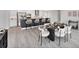 Stylish dining area with a modern table, upholstered chairs, an island with seating, and a view of the kitchen at 3941 14Th Ne Ln, St Petersburg, FL 33703