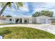 Beautiful home featuring a paved driveway, lush lawn, and modern architectural details at 3941 14Th Ne Ln, St Petersburg, FL 33703