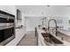 Sleek, modern kitchen featuring stainless steel appliances, white cabinetry, marble countertops, and stylish lighting fixtures at 3941 14Th Ne Ln, St Petersburg, FL 33703
